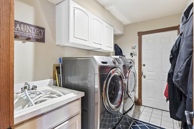 clothes washing area with cabinets, sink, washer and dryer, and light tile patterned flooring