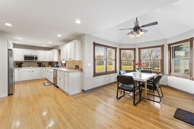 kitchen with a healthy amount of sunlight, white cabinetry, light wood-type flooring, and appliances with stainless steel finishes