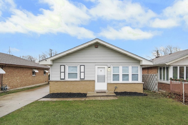 view of front of house featuring a front yard, brick siding, and fence