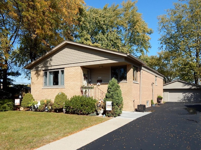 bungalow featuring an outbuilding, central AC, a garage, and a front lawn