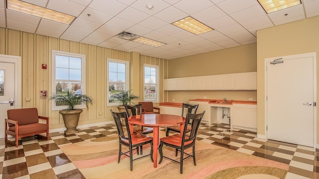 dining space featuring a drop ceiling, a healthy amount of sunlight, and sink