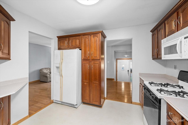 kitchen featuring white appliances and light hardwood / wood-style floors