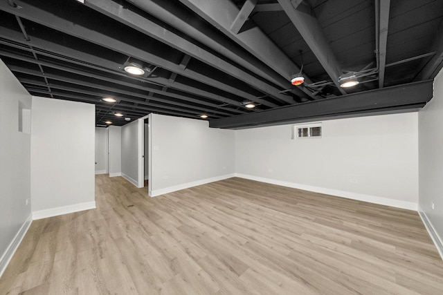 basement with light hardwood / wood-style floors