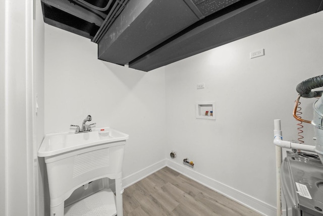 laundry room with hookup for a washing machine, hardwood / wood-style floors, and sink