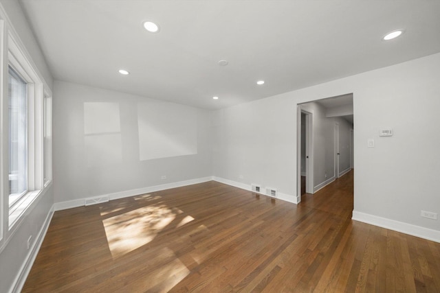 unfurnished room featuring plenty of natural light and dark hardwood / wood-style floors