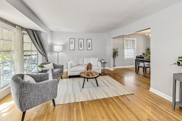 living room with light wood-type flooring and an inviting chandelier