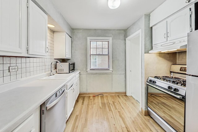 kitchen with light wood-type flooring, white cabinets, white refrigerator, dishwasher, and range with gas stovetop