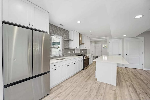 kitchen with a center island, stainless steel appliances, white cabinetry, and sink