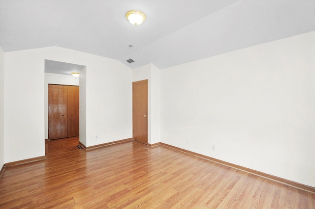 unfurnished room featuring light hardwood / wood-style flooring and vaulted ceiling