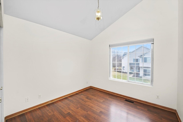 empty room featuring hardwood / wood-style floors and vaulted ceiling