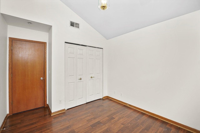 unfurnished bedroom with a closet, dark wood-type flooring, and lofted ceiling