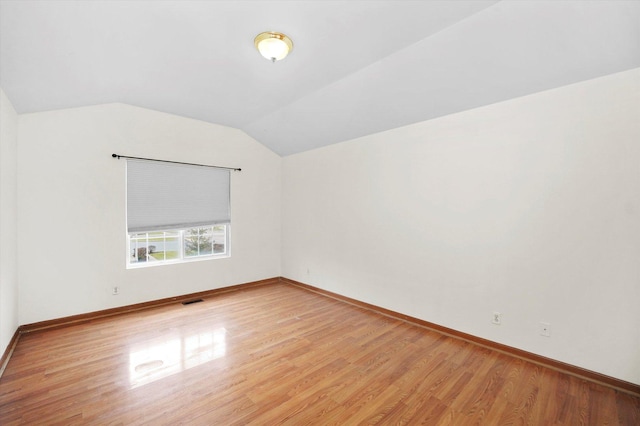 additional living space featuring light wood-type flooring and vaulted ceiling