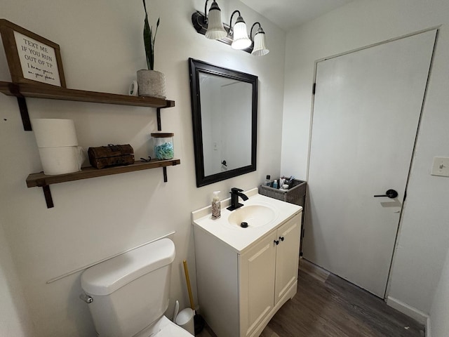 bathroom with vanity, toilet, and wood-type flooring