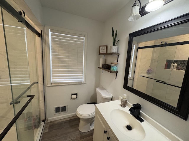 bathroom featuring vanity, toilet, an enclosed shower, and wood-type flooring