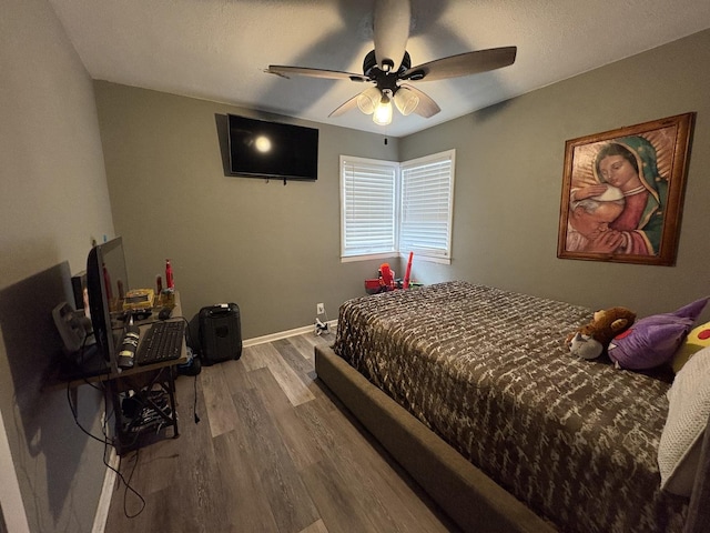 bedroom with ceiling fan and hardwood / wood-style flooring