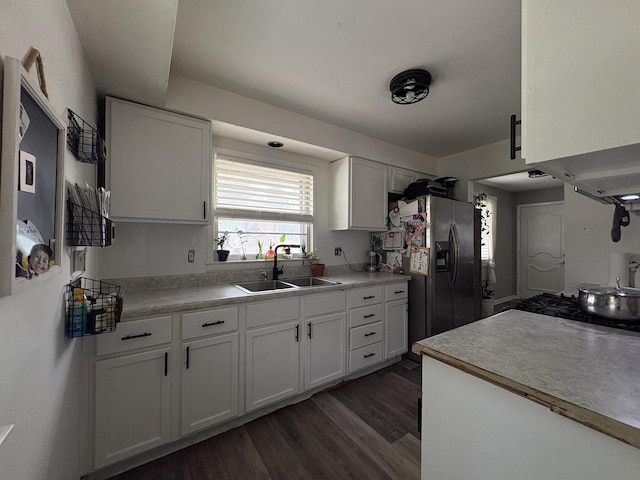 kitchen with white cabinetry, sink, and stainless steel refrigerator with ice dispenser