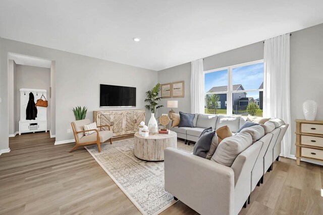 living room with light wood-type flooring and a notable chandelier