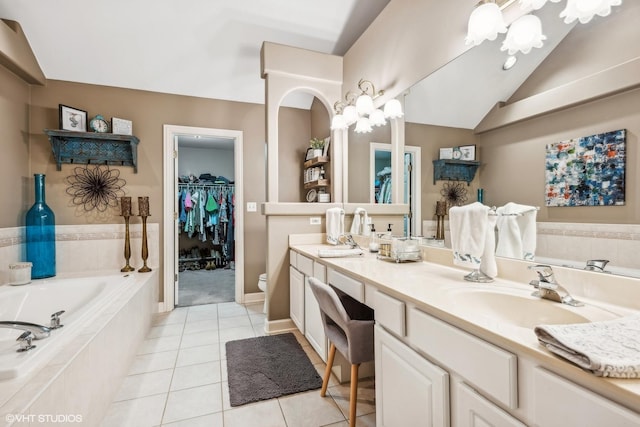 bathroom with vanity, a relaxing tiled tub, tile patterned flooring, toilet, and lofted ceiling