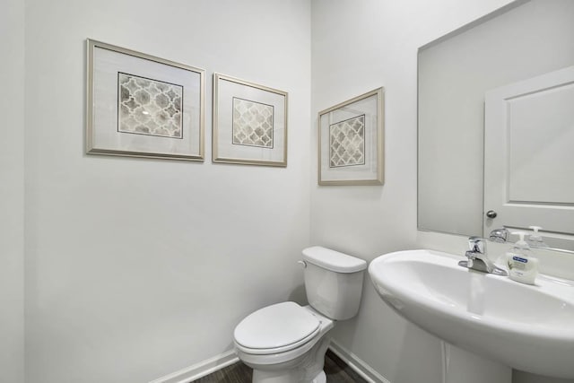 bathroom with hardwood / wood-style flooring, sink, and toilet