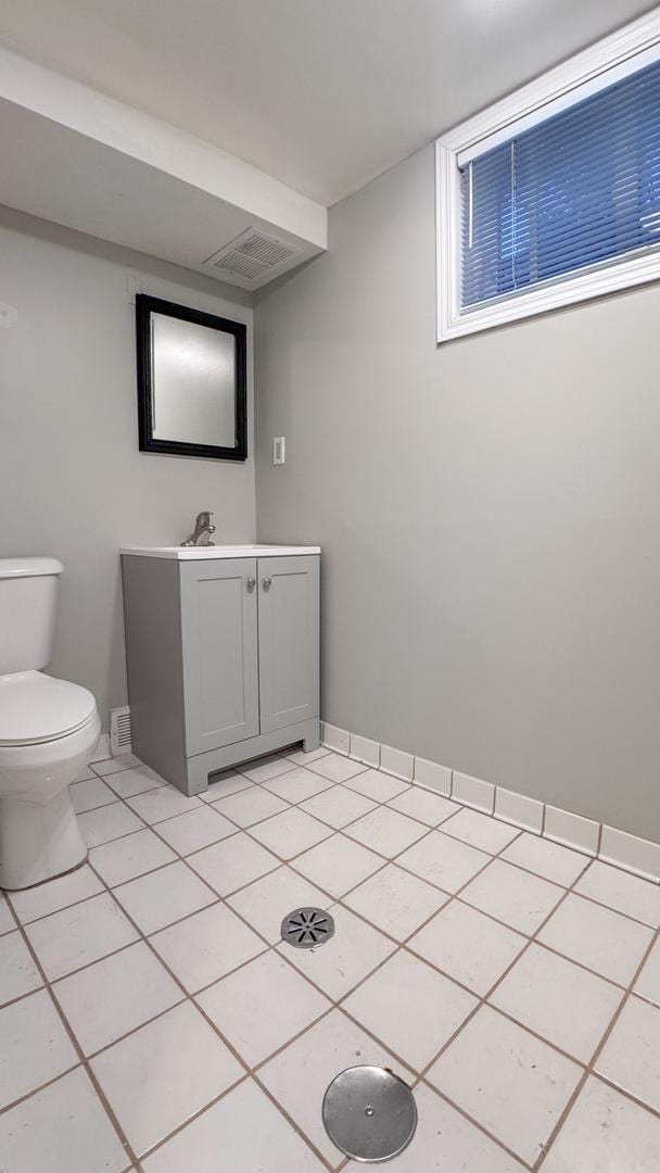 bathroom with tile patterned flooring, vanity, and toilet