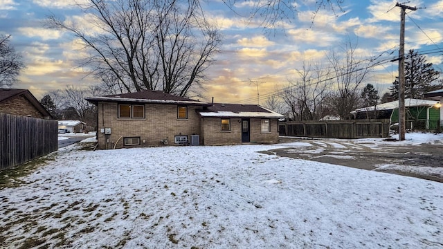 snow covered house featuring central AC