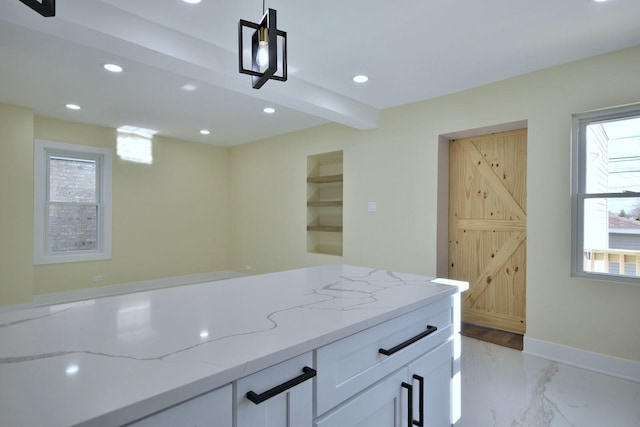 kitchen featuring white cabinets, beam ceiling, light stone counters, and hanging light fixtures