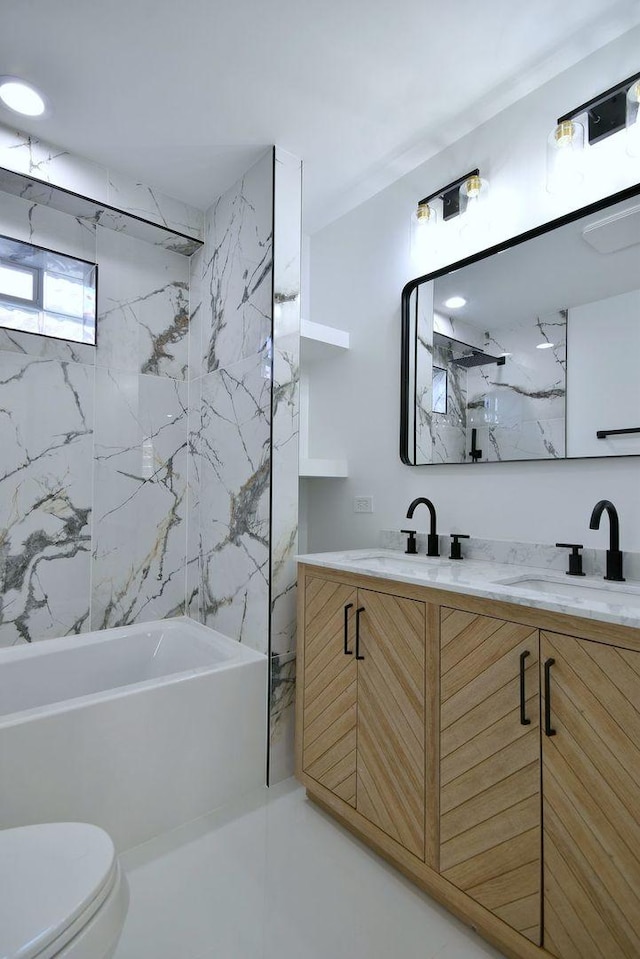 full bathroom with vanity, toilet, and tiled shower / bath