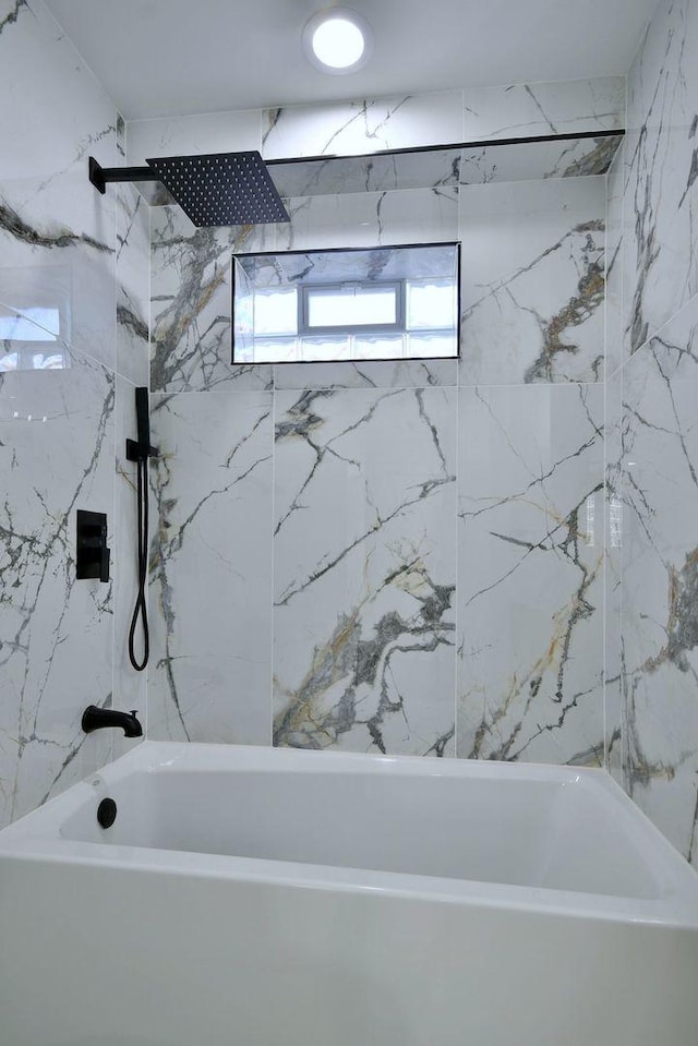 bathroom featuring tiled shower / bath