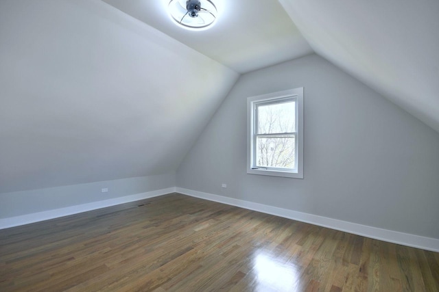 additional living space with vaulted ceiling and dark wood-type flooring