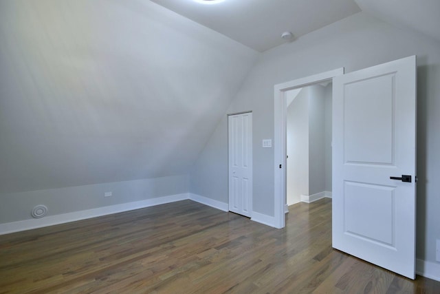 bonus room featuring vaulted ceiling and dark wood-type flooring