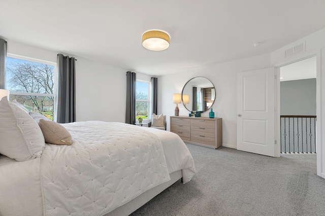 bedroom with light carpet and multiple windows