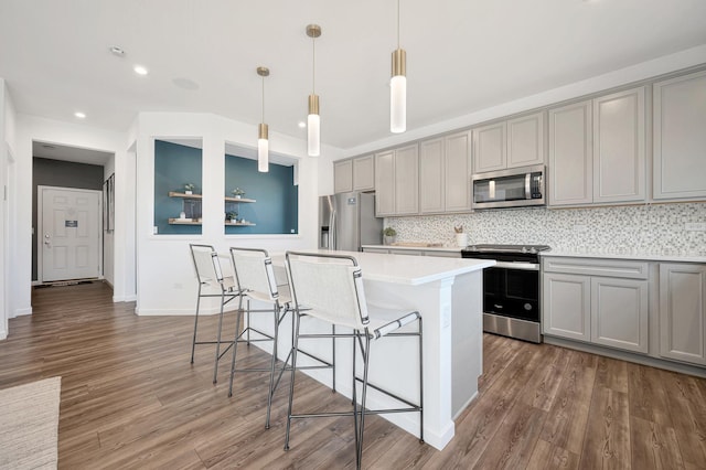 kitchen with appliances with stainless steel finishes, a kitchen island, and gray cabinetry