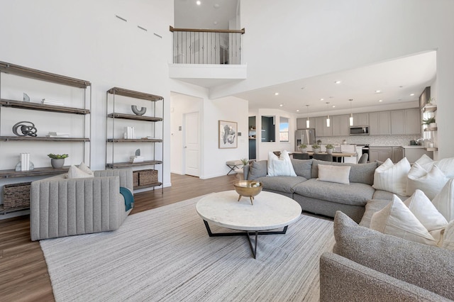 living room with a towering ceiling and light wood-type flooring