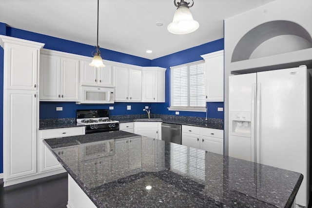 kitchen featuring pendant lighting, white appliances, white cabinets, a center island, and dark stone counters