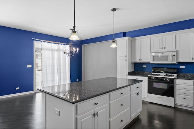 kitchen with range with gas stovetop, white cabinets, and hanging light fixtures