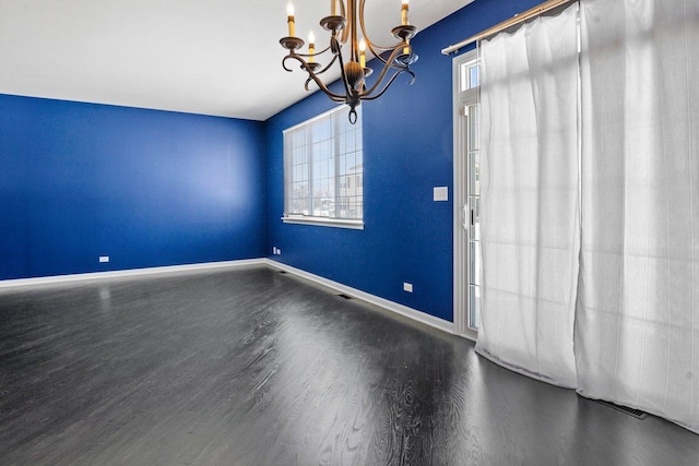 unfurnished room with dark wood-type flooring and a notable chandelier