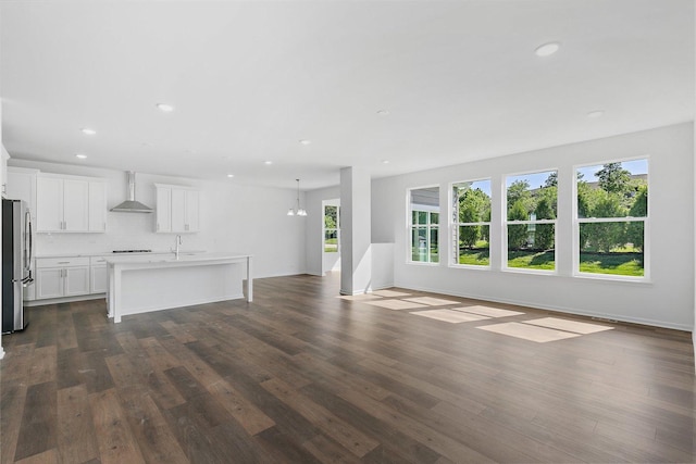 unfurnished living room featuring a chandelier, dark hardwood / wood-style flooring, and sink