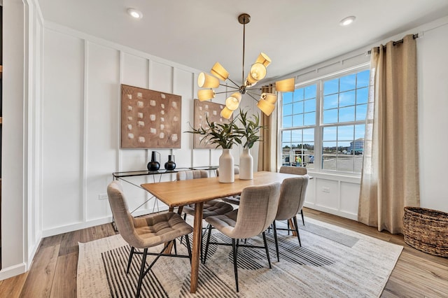 dining space featuring light hardwood / wood-style flooring and a chandelier