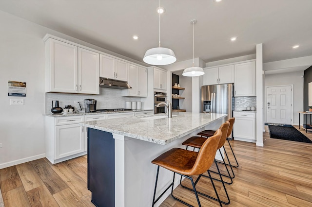 kitchen with white cabinetry, a kitchen island with sink, and decorative light fixtures