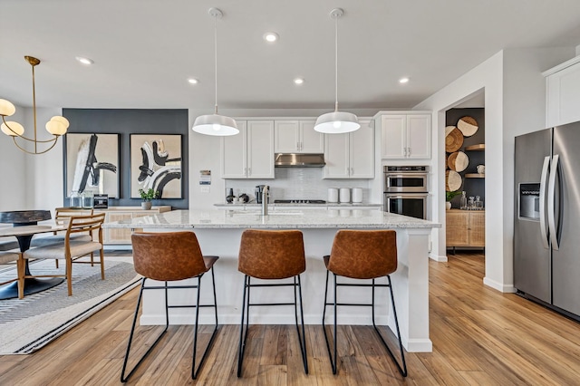 kitchen featuring a center island with sink, white cabinets, and appliances with stainless steel finishes