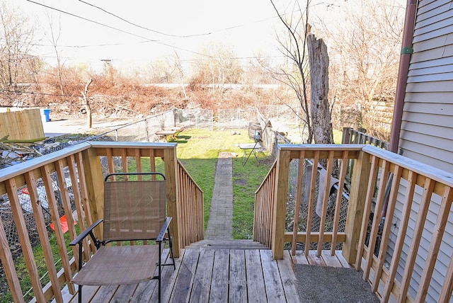 wooden deck featuring a lawn