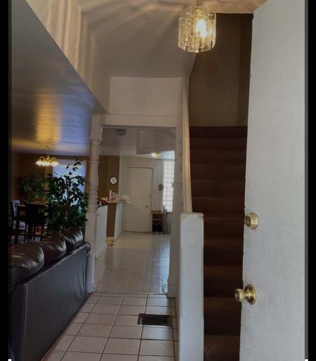 hallway featuring tile patterned floors and a chandelier