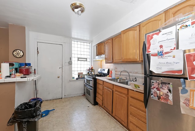 kitchen with tile countertops, sink, and stainless steel appliances