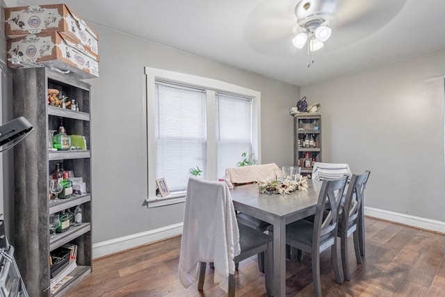 dining area with ceiling fan and dark wood-type flooring