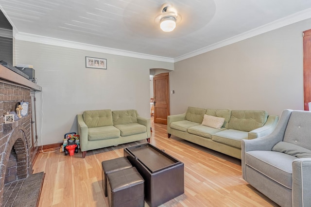 living room with a fireplace, light hardwood / wood-style flooring, and ornamental molding