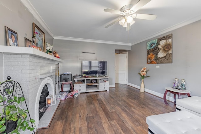 living room with ceiling fan, dark hardwood / wood-style flooring, crown molding, and a fireplace