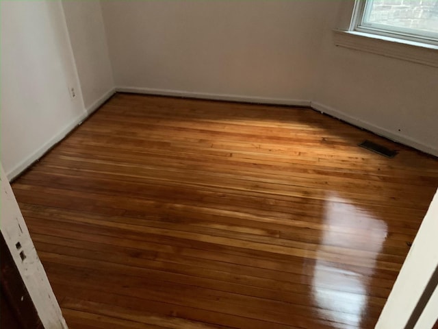 unfurnished room with hardwood / wood-style flooring