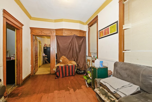 living area featuring crown molding and hardwood / wood-style floors