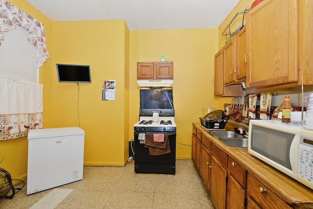 kitchen featuring sink, refrigerator, and black range with gas cooktop