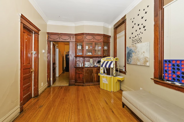 hall featuring crown molding and light hardwood / wood-style flooring